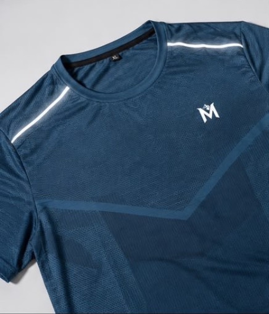Close-up of deep teal tee fabric and chest logo